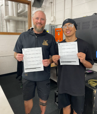 Coach John Rowbotham and Marcelo Alvarado Grade 12th holding the academic tracker in their hands.